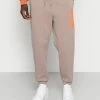 Jack & Jones JJIKANE BRINK CLUB - Tracksuit Bottoms - Fungi/sun Orange